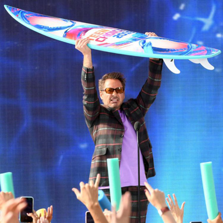 Robert Downey Jr. lifting the Teen Choice surf board.